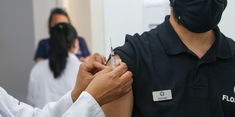adulto sendo vacinado contra covid