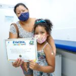 criança com certificado nas mãos