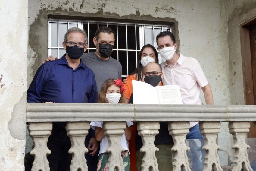 famílias e autoridades durante ato de entrega de escritura