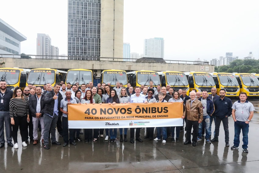prefeito Orlando Morando ao lado de ônibus novos