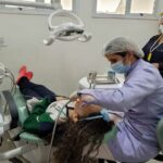 aluna sendo atendida no consultório odontológico